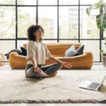 ラップトップを使用してオンラインビデオ瞑想レッスンで自宅で瞑想する若い多人種ラテン系女性